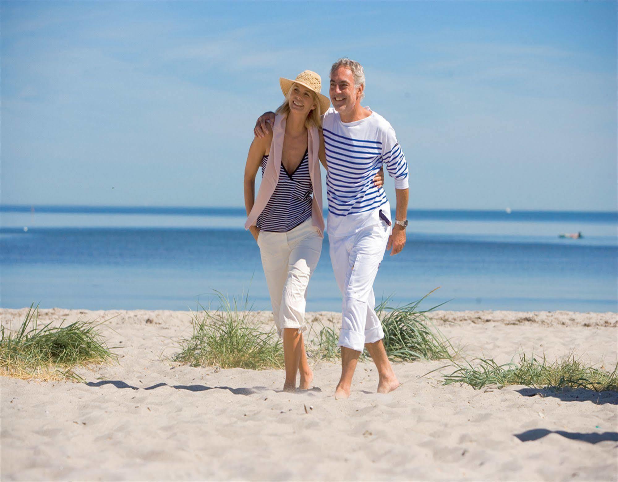 Отель Yachthafenresidenz Hohe Duene Росток Экстерьер фото A couple walking on the beach